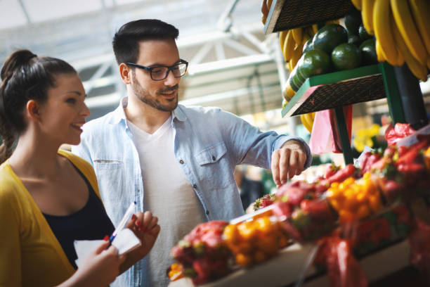 istock Young couple buying fruit at a market. 1218770429