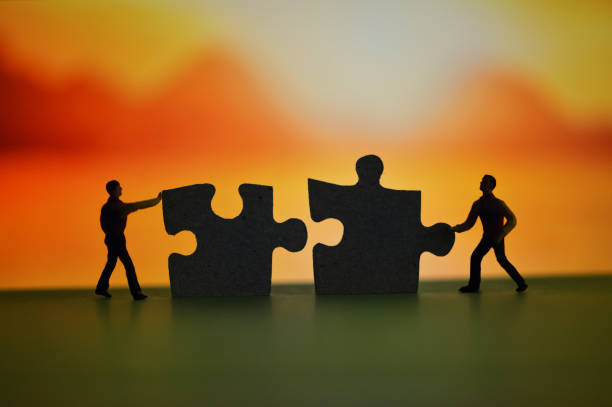 istock Miniature Men Connect Puzzle Pieces in Nature 1218770846
