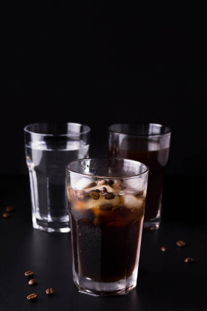 istock iced coffee on a black background next to coffee beans and ingredients 1218771889