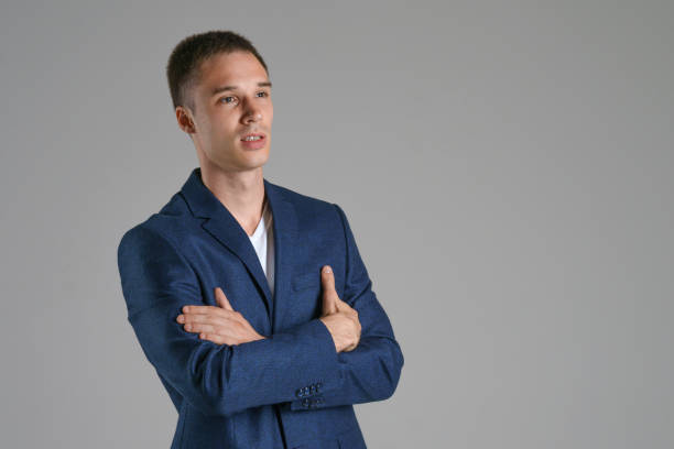 istock A young businessman in a blue jacket on a gray background 1218772278
