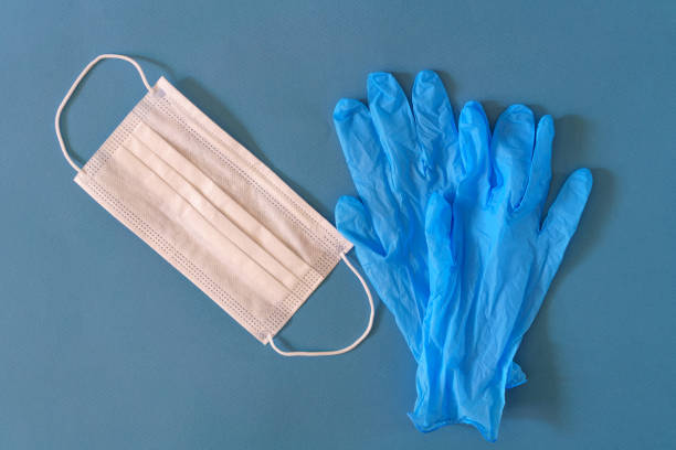 istock Medical mask and gloves on a blue background 1218773119