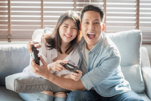 istock Asian couple lovers enjoy and play console game on vacation 1218773625