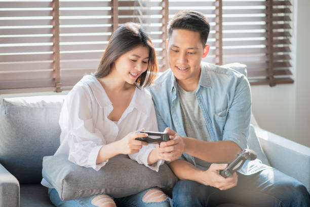 istock Asian couple lovers enjoy and play console game on vacation 1218773720