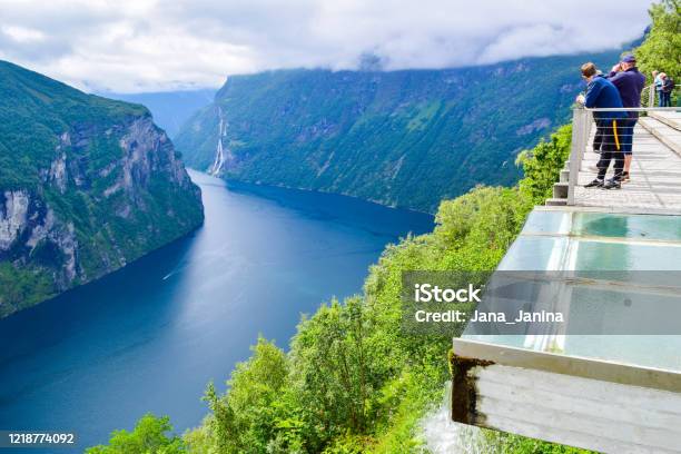 I Turisti Guarda Geirangerfjord E Cascata Delle Sette Sorelle Vicino Al Piccolo Villaggio Di Geiranger - Fotografie stock e altre immagini di Adulazione
