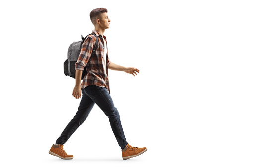 Estudiante masculino con una mochila caminando photo