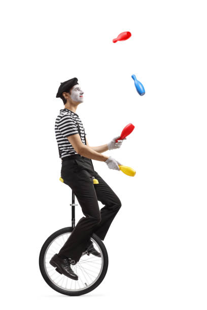 istock Pantomime guy riding a mono-cycle and juggling 1218775535