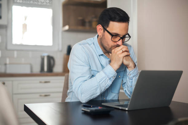 istock Young man looking worried while watching in laptop. 1218775773