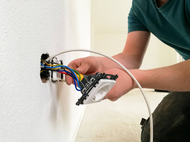 istock Electrician installs an electrical outlet with his hands 1218776839