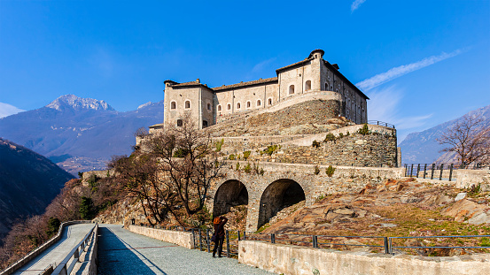 Tourist taking picture to the Bard Fortress, a fortified complex dating back to the Middle Ages, now hosting the Museo delle Alpi, Museum of the Alps.