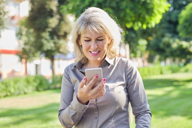 istock Middle aged confident business woman with smartphone 1218777790