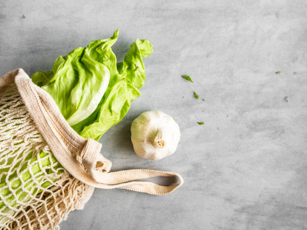 Green vegetables in a reusable shopping bag on a gray table