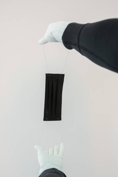 istock Man holds rubber gloves black face masks 1218782266