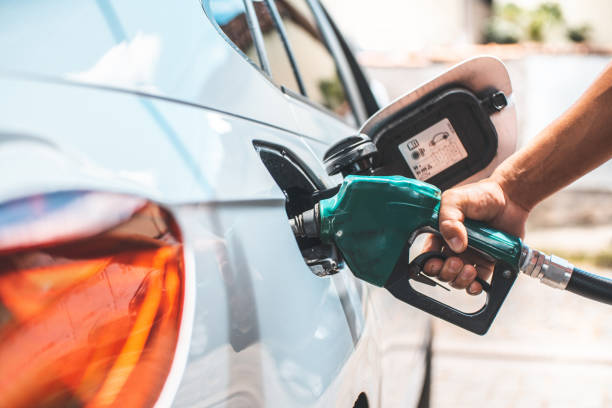 dettaglio del riempimento a mano del serbatoio del carburante - gas station foto e immagini stock