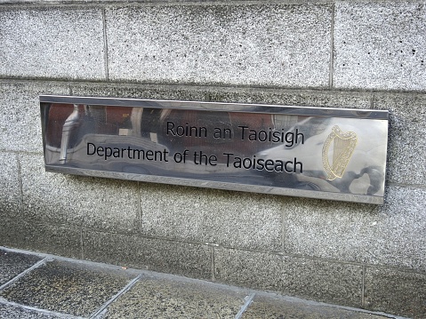13th April 2020, Dublin, Ireland. Department of the Taoiseach silver mirror wall sign in English and translated directly into the Irish language outside Government Buildings on Merrion Street, Dublin,