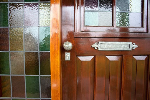 Front door with stained glass and metal door knob, vintage design close-up antique