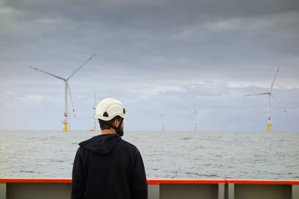 istock Technician standing on transfer vessel deck and preparing equipment for offshore project in the morning and offshore wind farm and offshore platform is behind 1218789518