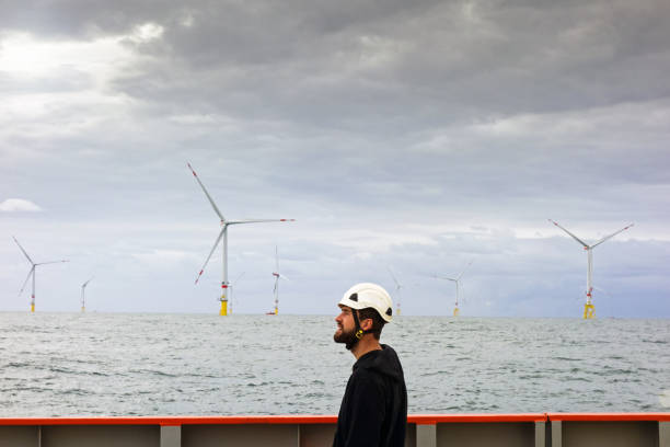 istock Technician standing on transfer vessel deck and preparing equipment for offshore project in the morning and offshore wind farm and offshore platform is behind 1218789587