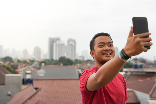 istock Southeast Asian Man Make Video Call with City on the Background 1218789755