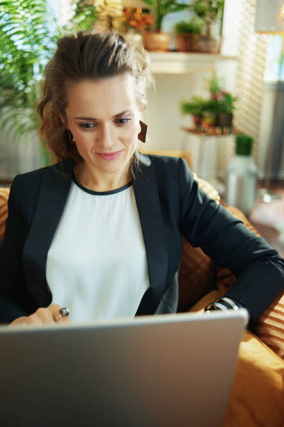 istock young housewife reading on laptop while sitting on couch 1218790855