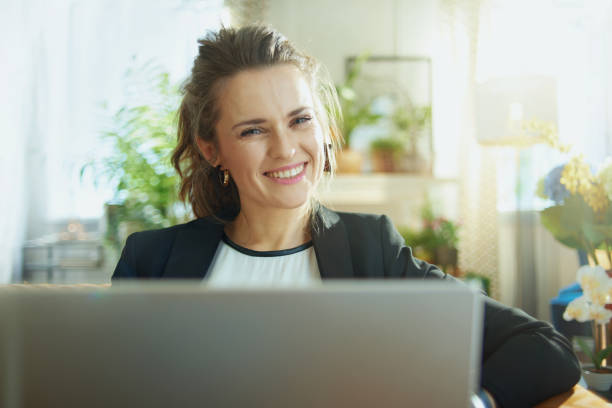 istock smiling stylish woman using website while sitting on couch 1218791024