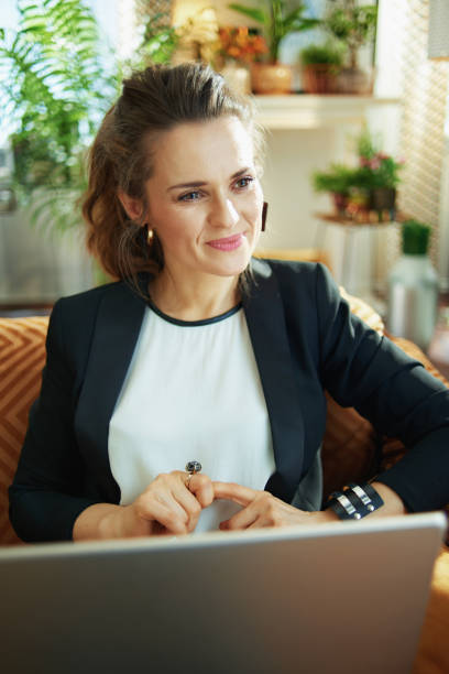 istock smiling stylish woman doing research while sitting on divan 1218791050