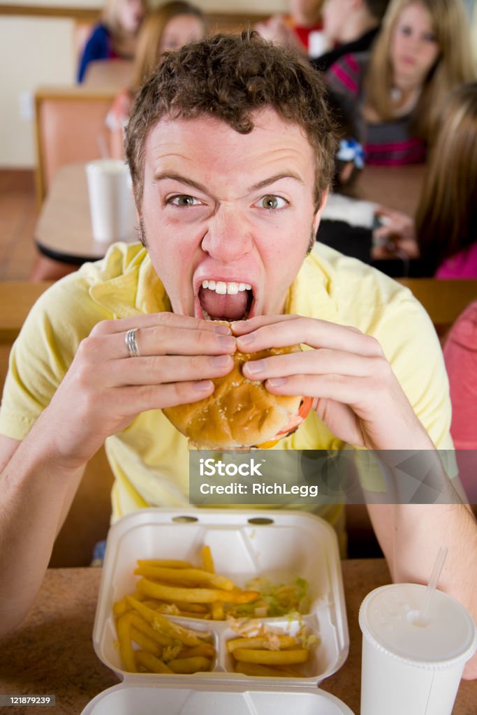 Jovem comendo um Cheeseburger - Foto de stock de Comer royalty-free