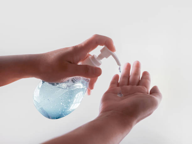 istock hands using wash hand sanitizer gel pump 1218795925