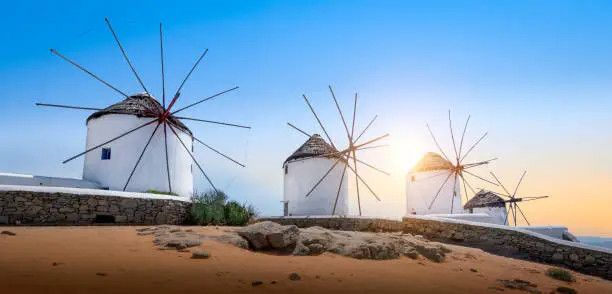 Photo of Mykonos, Greece. Famous white old windmills at sunset. Panoramic view.
