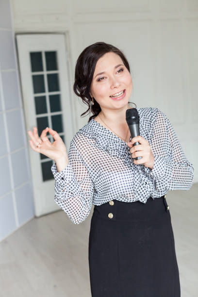 istock Asian woman talks into microphone sings nice 1218801953