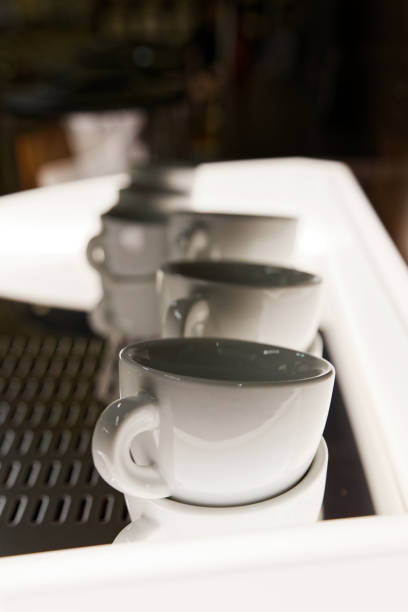 istock Closeup row of white empty coffee cups against blurred background. Shallow focus. 1218803607