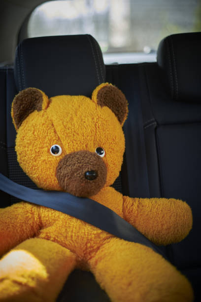 istock Teddy Bear Sitting On Car Seat With Belt Buckled 1218804142