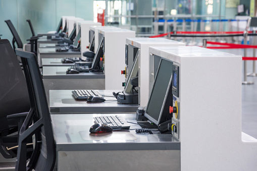 Row of empty check-in desks with computer monitors at the airport