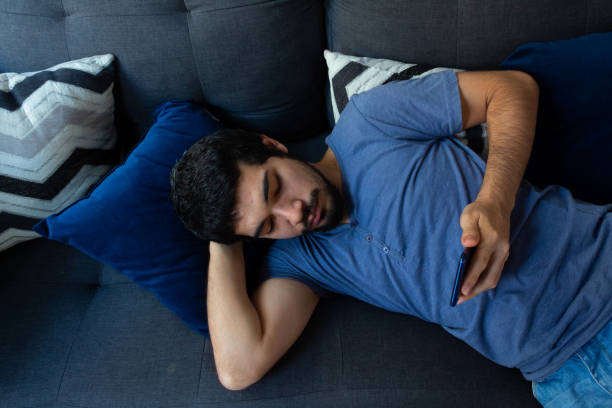 istock Millennial Hispanic young man resting in his living room, using his smartphone sharing things with people online 1218804793
