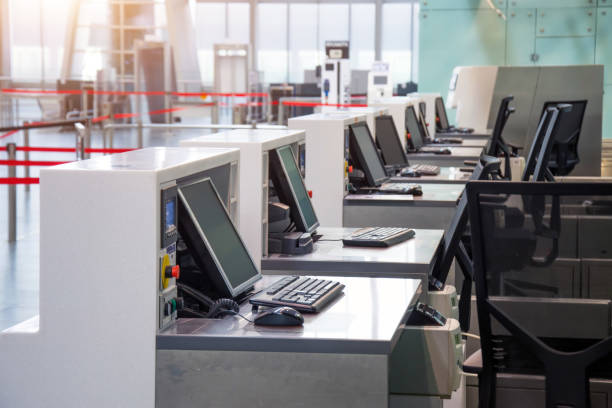 istock Row of empty check-in desks with computer monitors at the airport. 1218804798