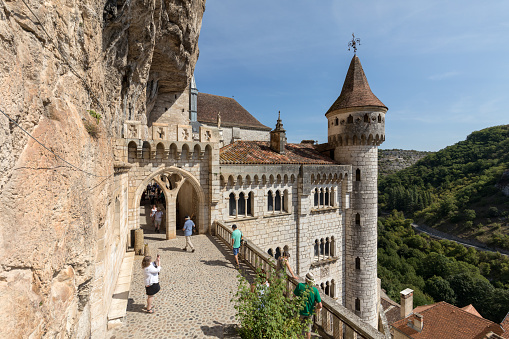 Rocamadour, France - September 3, 2018: Stone walls of historic Basilica of St-Sauveur blend into the cliff in Rocamadour, France