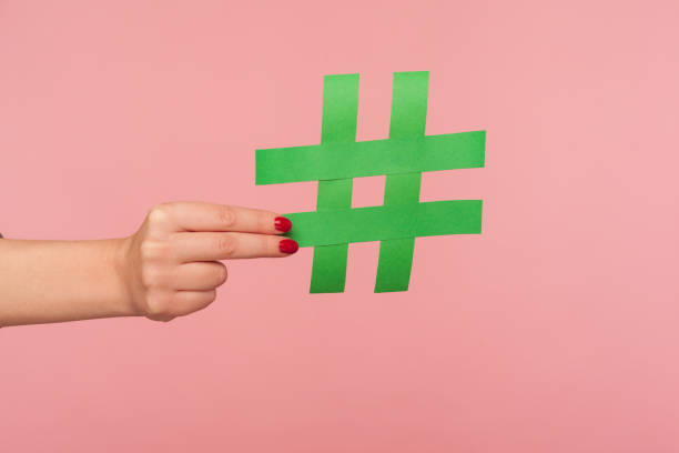блог маркетинга, социальных медиа тенденции. крупным планом женской руки проведение зеленый знак хэштега, обмен помечены сообщения - hash sign стоковые фото и изображения