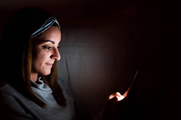 istock young woman at home using mobile phone. Night time 1218808751