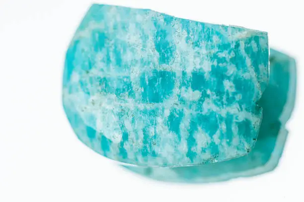 Macro shooting of natural gemstone. Raw mineral amazonite. Isolated object on a white background