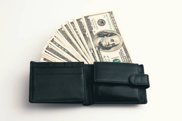 istock A black wallet with dollars in it on a white background. 1218810308