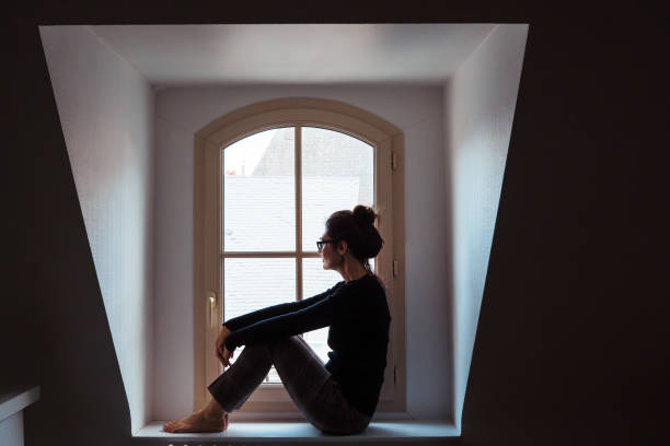 isolated woman worried looking through the window at home. - claustrophobic imagens e fotografias de stock