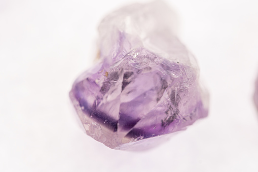 Close-up of an amethyst crystal on a white background.
