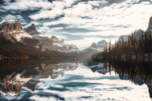 canoa viaggiatore a spirit island con montagne rocciose canadesi sul lago maligne al jasper national park - lago maligne foto e immagini stock