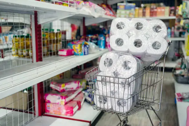 Customer hoarding tissue, toilet paper on shopping cart in retailer. During epidemic of Coronavirus, Covid-19