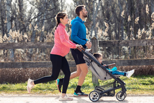 sporty young couple with her little son running while enjoying the time together outdoor. - relaxation exercise child mother human pregnancy imagens e fotografias de stock