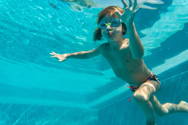 istock Little boy is diving in swimming pool 1218816132