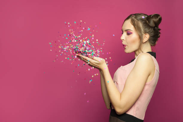 istock Nice woman blowing colorful confetti 1218817658