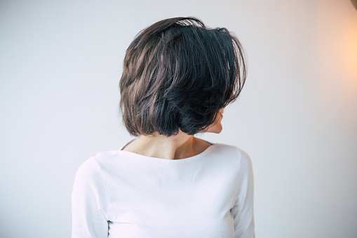 Peinado fresco. Foto de primer plano de una joven hermosa chica con el pelo corto oscuro que se alejó de la cámara y muestra su nuevo peinado de pelo. photo