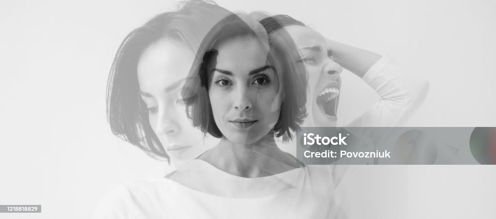 Multiple identities. Close-up photo of a young pretty brunette girl who is looking in the camera while internally suffering from a dissociative identity disorder. Double exposure. Young pretty brunette girl who is looking in the camera while internally suffering from a dissociative identity disorder. Double exposure. Schizophrenia Stock Photo