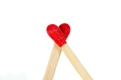 matchstick with a red heart-shaped head on a white background close-up