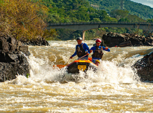 gruppo di amici che fa rafting su un gommone nelle rapide del fiume itajaí-açu, nella città di apiúna a santa catarina. uno dei migliori fiumi del brasile per praticare questo sport - teamwork oar achievement sports team foto e immagini stock